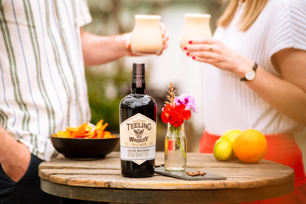 Teeling Frozen Irish Coffee enjoyed by a man and women outside with Teeling Small batch on a table